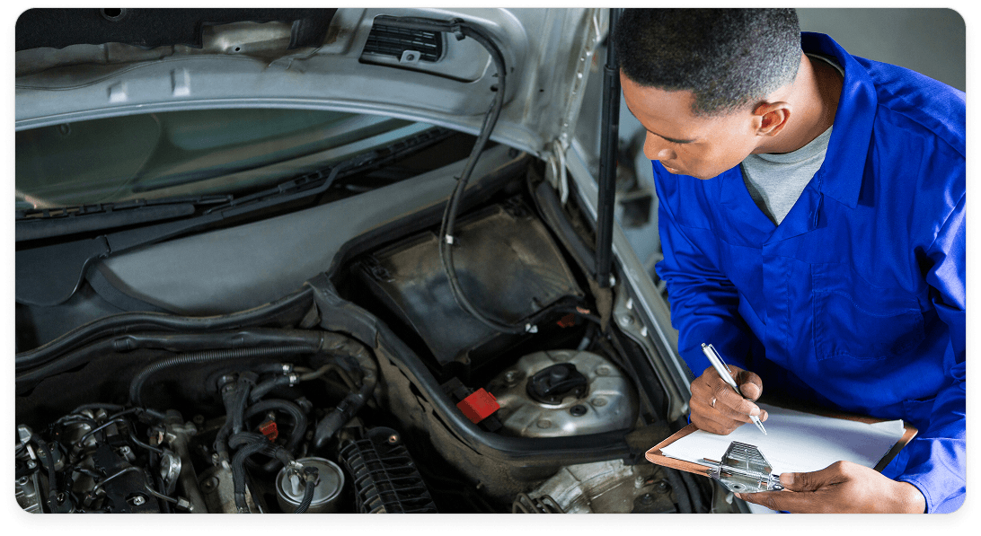 Mecânico inspecionando motor de um carro
